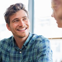 Man in blue plaid shirt smiling at friends