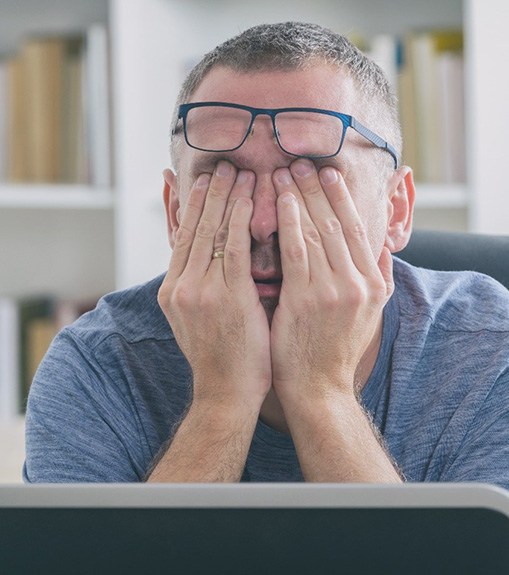 Very tired man sitting at his computer