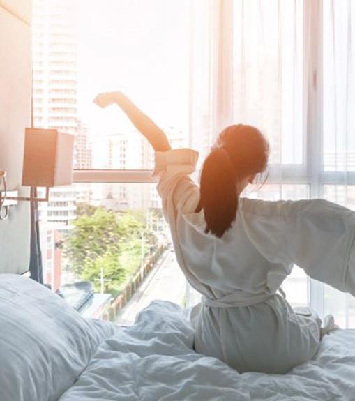 Woman waking up refreshed after good night’s sleep