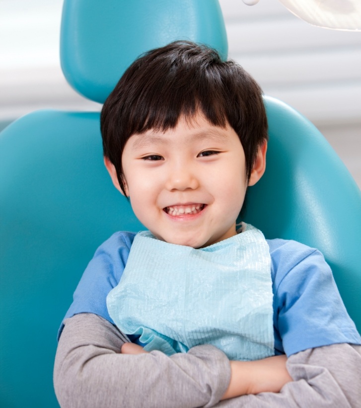 Young boy grinning in dental chair