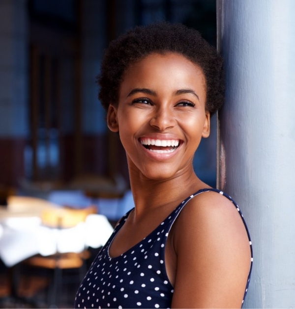 Woman in sleeveless blouse smiling after cosmetic dentistry in Beaverton