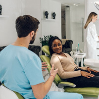 dentist talking to smiling patient during exam