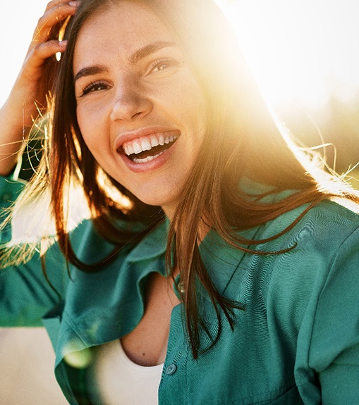 Happy woman standing outside during the golden hour