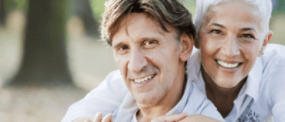 Smiling senior man and woman hugging outdoors