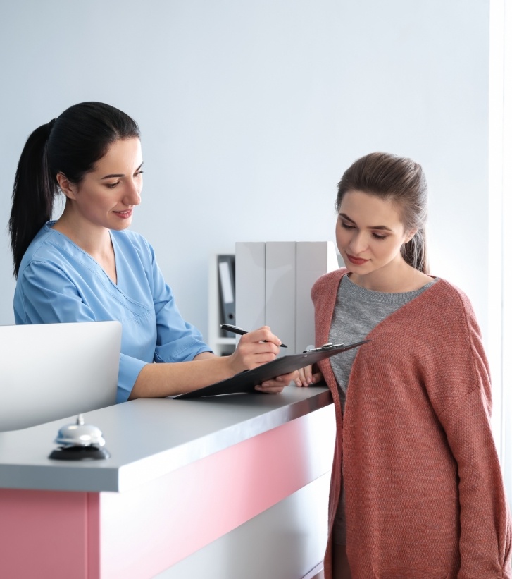 Dental team member showing a clipboard to a patient