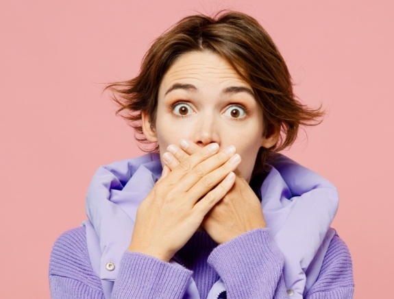 Woman covering her mouth with her hands