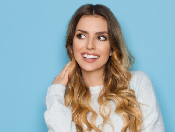 Woman smiling against light blue background