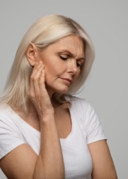 Woman holding the side of her jaw in pain