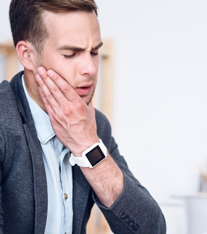 Man holding his jaw in pain