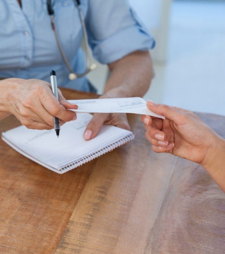 Person handing a check to person sitting across desk