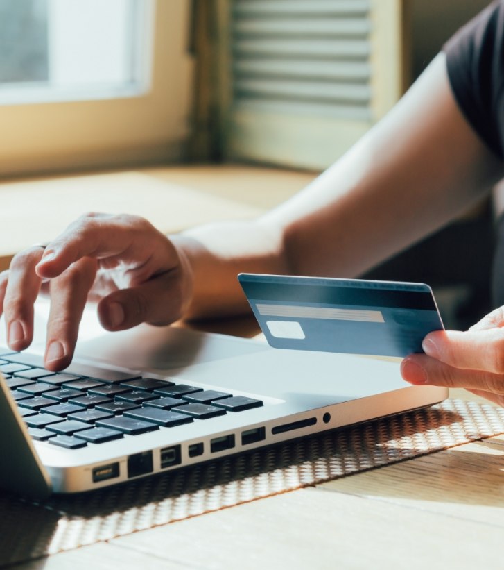 Person typing credit card information onto a laptop