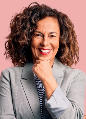 Woman in gray blazer smiling and resting her chin in her hand