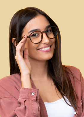 Brunette woman touching her glasses and smiling