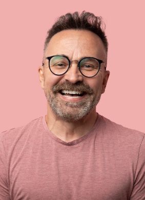 Man in pink shirt grinning