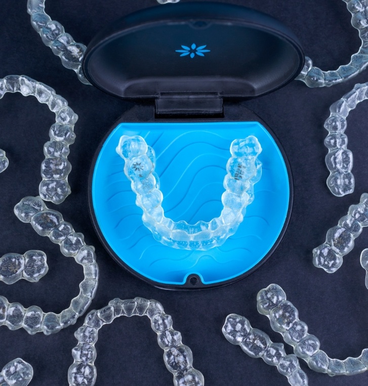 Several Invisalign clear aligners in Beaverton on table with one in its case