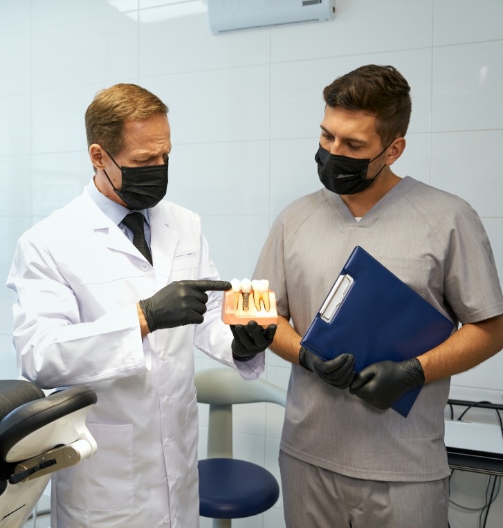 Two Beaverton dentists looking at dental implant model