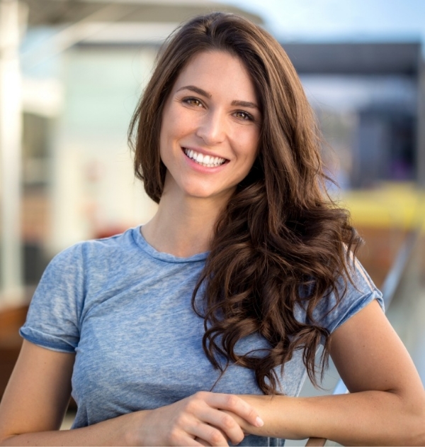 Woman in blue shirt smiling after preventive dentistry in Beaverton