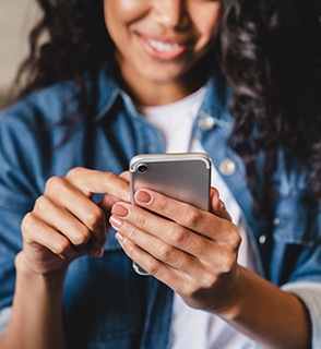 Young woman typing on her phone