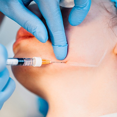 Patient receiving BOTOX injection near her jaw