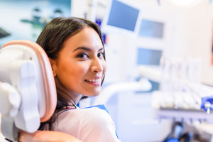 Woman in dental chair looking back and smiling