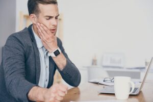 Man experiencing a dental emergency while working overseas